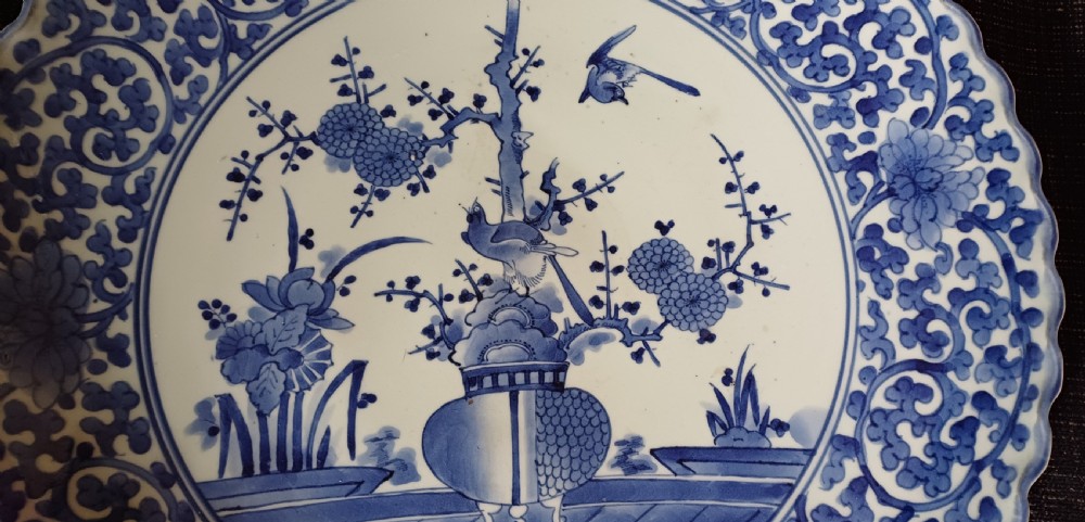 A large round Japanese Arita blue and white porcelain charger with a scalloped rim, hand-painted birds, flowers, and dense scrolling leaf borders. View XIII
