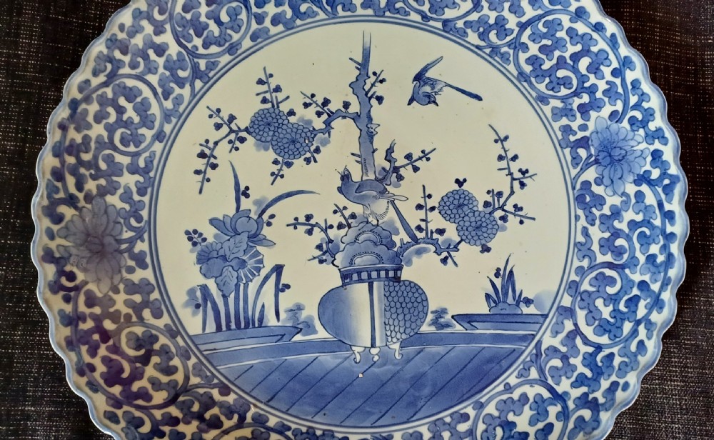 A large round Japanese Arita blue and white porcelain charger with a scalloped rim, hand-painted birds, flowers, and dense scrolling leaf borders. View XVI