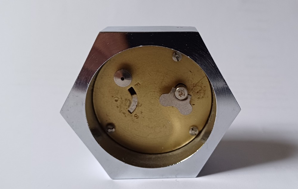 (Reserved EK) A fantastic small Smiths desk clock in the design of a motoring hexagonal wheel nut, as designed for a set of sports car wire wheels, dating circa 1940’s  View VIII
