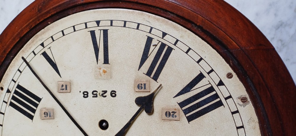 An early 20th-century round mahogany railway wall clock featuring an off-white dial with Roman numerals, secondary 24-hour markings, and B.R.(E.) lettering. View V