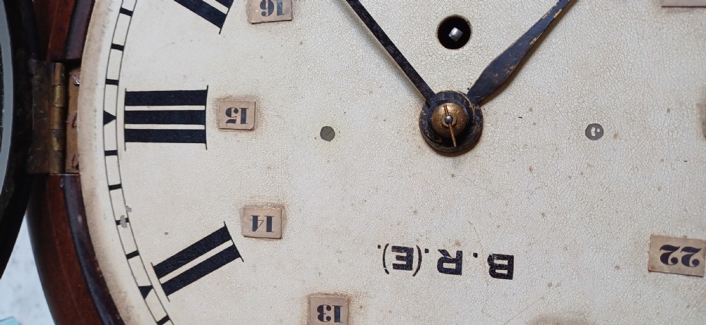 An early 20th-century round mahogany railway wall clock featuring an off-white dial with Roman numerals, secondary 24-hour markings, and B.R.(E.) lettering. View XI