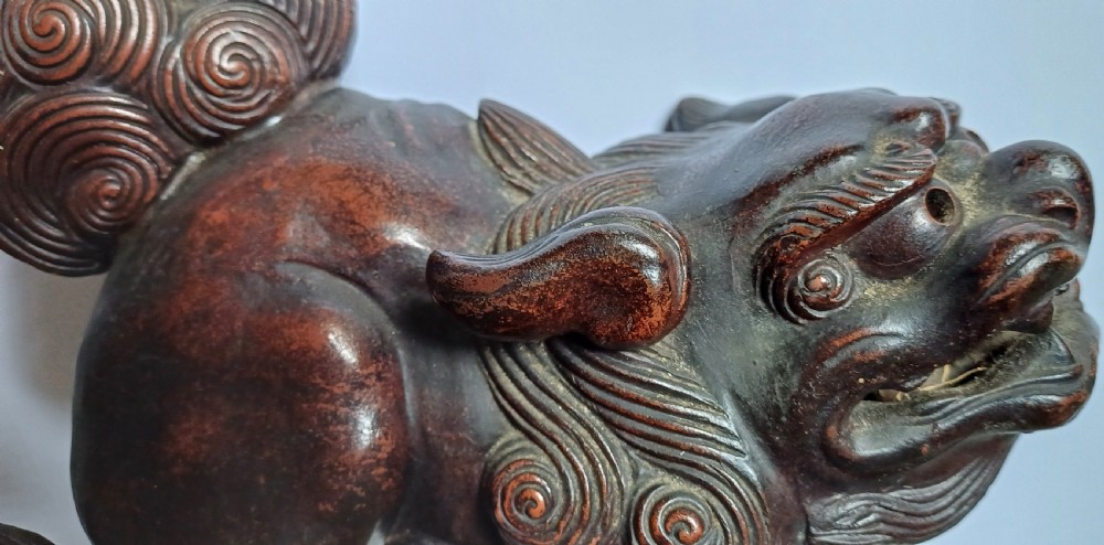 A dark brown Japanese Bizen stoneware Shishi lion dog sculpture with swirling carved details on its mane and tail. View V