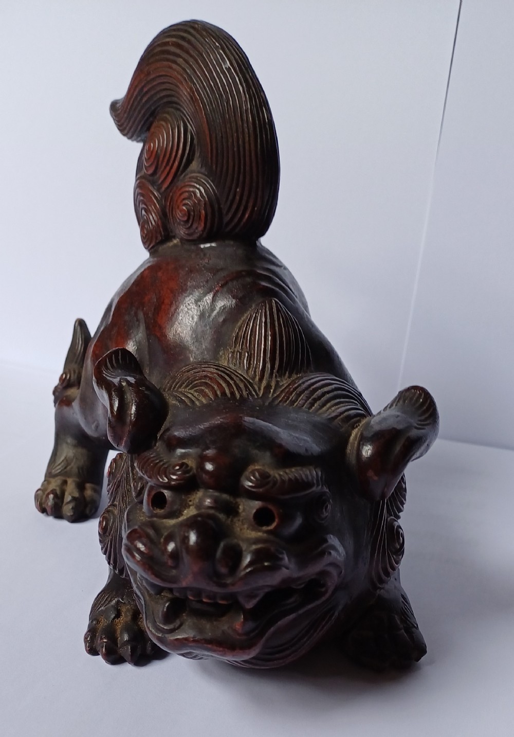 A dark brown Japanese Bizen stoneware Shishi lion dog sculpture with swirling carved details on its mane and tail. View XVII