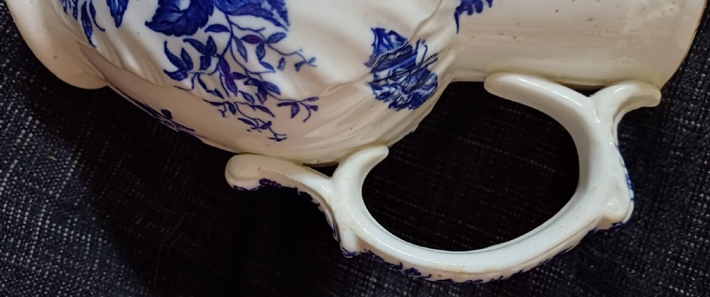 A Georgian porcelain jug featuring blue transferware floral and pine cone patterns with a moulded mask spout and ribbed body. View XXII