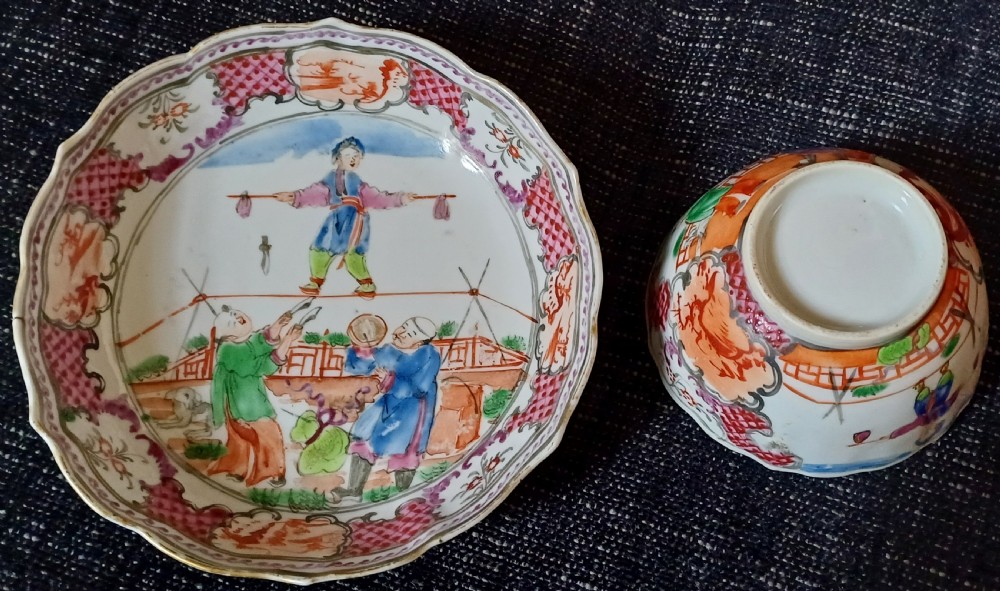 An 18th-century Chinese Mandarin palette porcelain tea bowl and saucer decorated with hand-painted acrobatic figures and pink diaper borders.