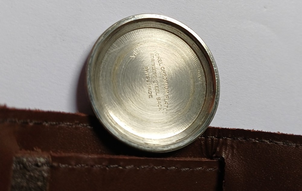 A vintage 1940s military wristwatch with a cream dial, Arabic numerals, sub-seconds display, and a wide brown leather cuff strap. View IX