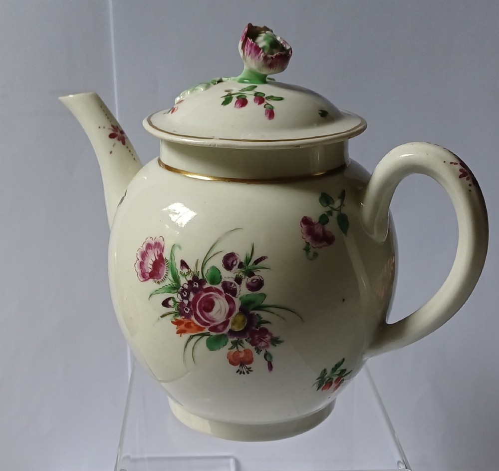 An 18th-century Dr Wall period Worcester porcelain teapot featuring hand-painted floral sprays, a loop handle, and a floral knop lid.