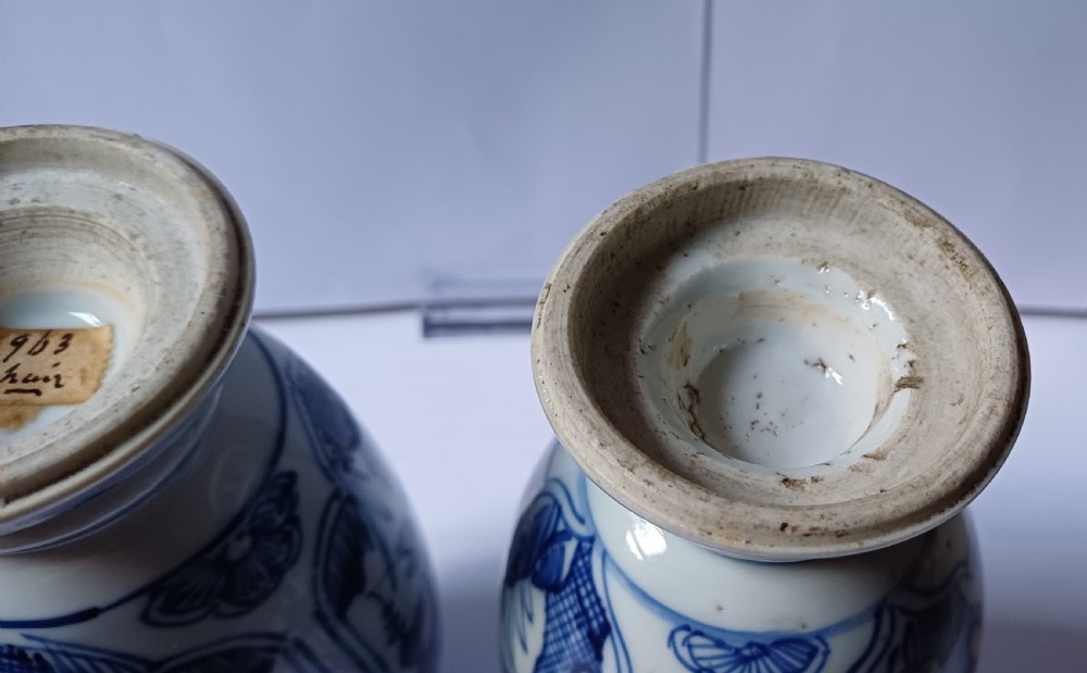 A pair of antique Chinese Kangxi period ovoid porcelain jars with fitted lids, decorated with hand-painted cobalt blue floral motifs on a white background. View VI