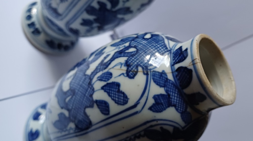 A pair of antique Chinese Kangxi period ovoid porcelain jars with fitted lids, decorated with hand-painted cobalt blue floral motifs on a white background. View XI