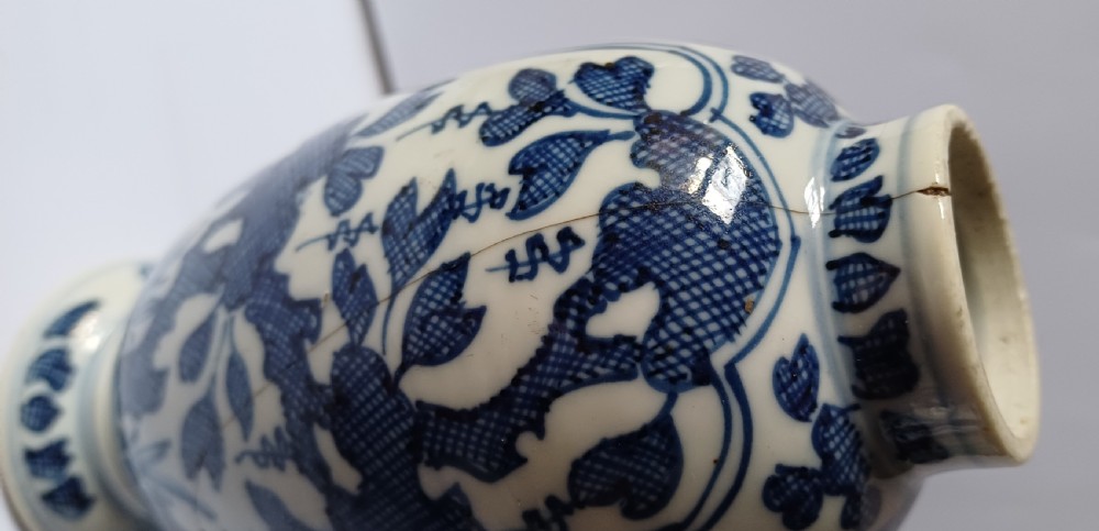 A pair of antique Chinese Kangxi period ovoid porcelain jars with fitted lids, decorated with hand-painted cobalt blue floral motifs on a white background. View XII