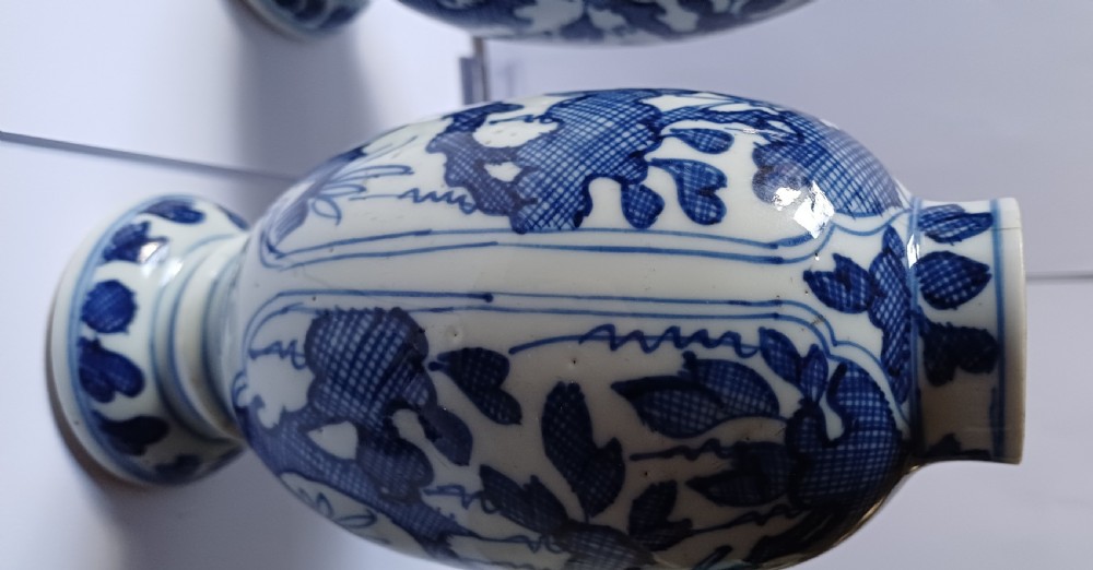 A pair of antique Chinese Kangxi period ovoid porcelain jars with fitted lids, decorated with hand-painted cobalt blue floral motifs on a white background. View XVI