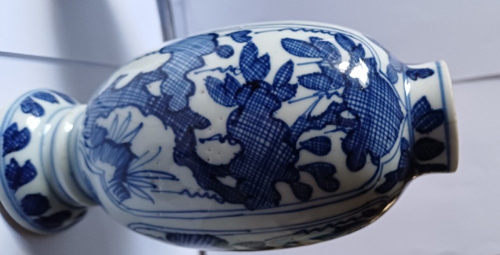A pair of antique Chinese Kangxi period ovoid porcelain jars with fitted lids, decorated with hand-painted cobalt blue floral motifs on a white background. View XVII
