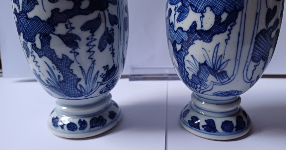 A pair of antique Chinese Kangxi period ovoid porcelain jars with fitted lids, decorated with hand-painted cobalt blue floral motifs on a white background. View XX