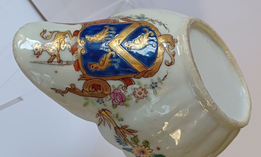 An 18th-century Chinese export famille rose porcelain sauce boat decorated with a hand-painted crest, coat of arms, and floral motifs. View VI