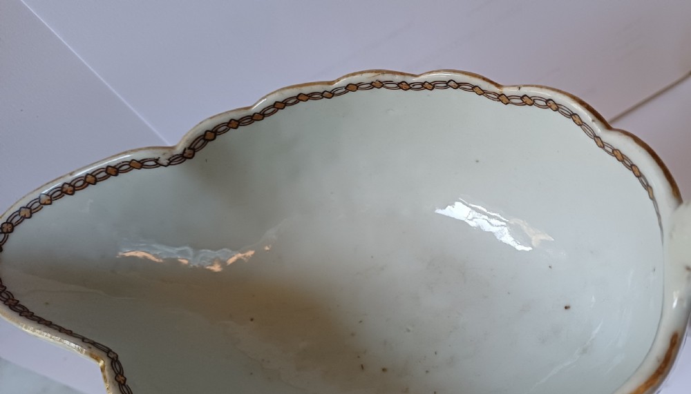 An 18th-century Chinese export famille rose porcelain sauce boat decorated with a hand-painted crest, coat of arms, and floral motifs. View XIII