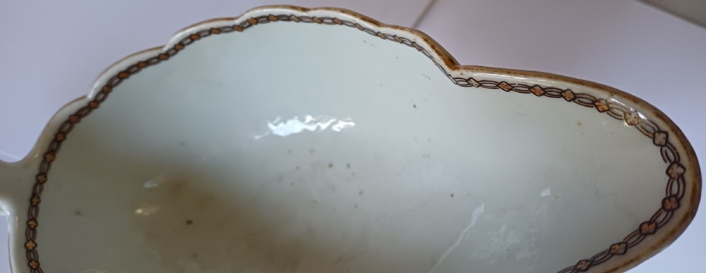 An 18th-century Chinese export famille rose porcelain sauce boat decorated with a hand-painted crest, coat of arms, and floral motifs. View XIV