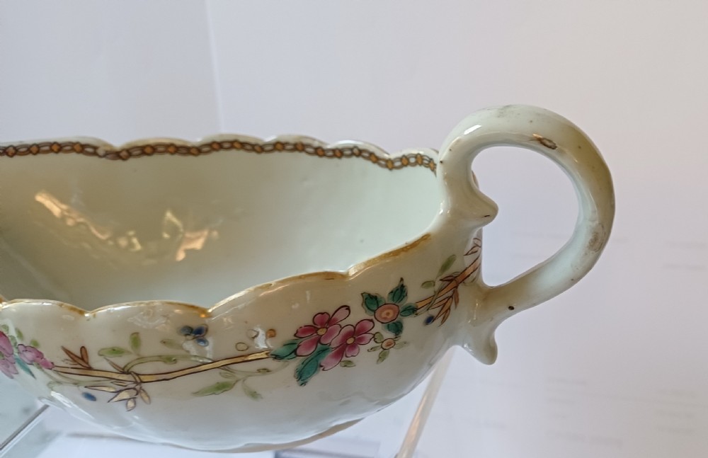 An 18th-century Chinese export famille rose porcelain sauce boat decorated with a hand-painted crest, coat of arms, and floral motifs. View XV