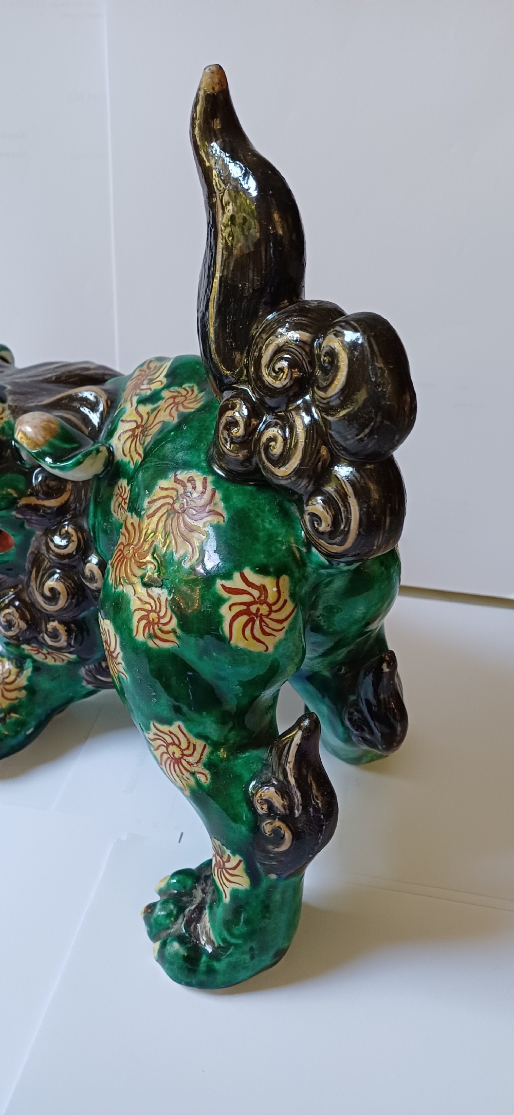 A Japanese Kutani glazed porcelain Shishi lion featuring a vibrant emerald green body decorated with gold floral motifs and a dark scrolling mane. View XVI