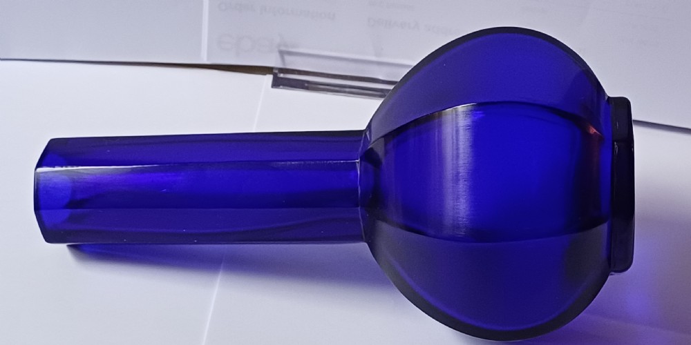 A cobalt blue glass bottle vase featuring an octagonal faceted globular body and a tall matching octagonal neck. View II
