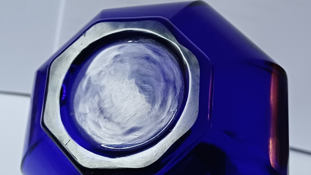 A cobalt blue glass bottle vase featuring an octagonal faceted globular body and a tall matching octagonal neck. View VII