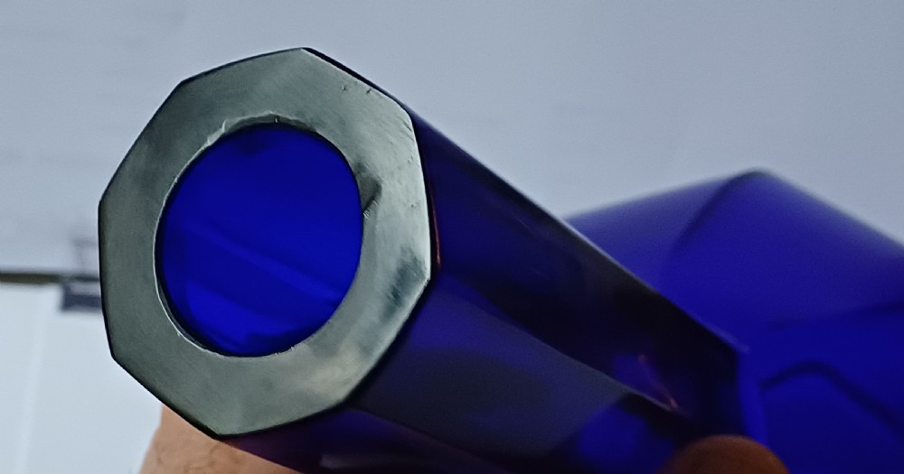 A cobalt blue glass bottle vase featuring an octagonal faceted globular body and a tall matching octagonal neck. View XI