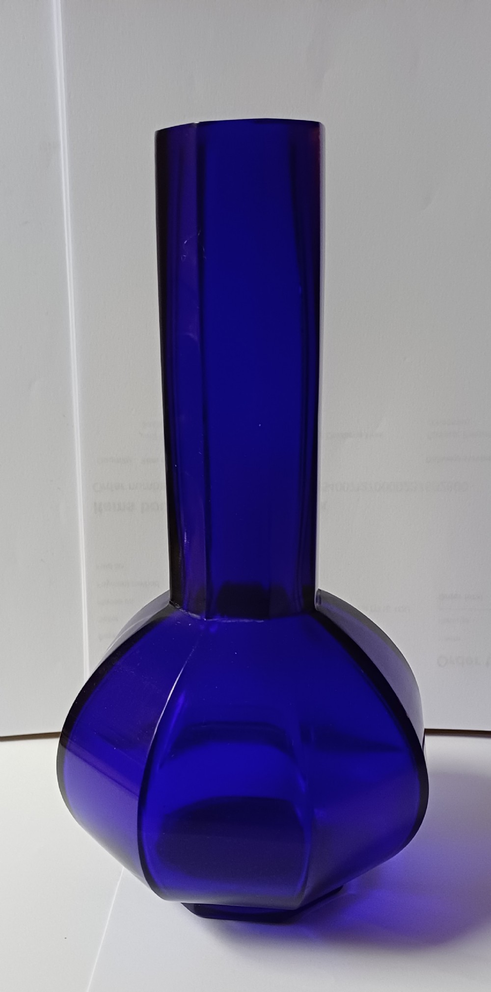 A cobalt blue glass bottle vase featuring an octagonal faceted globular body and a tall matching octagonal neck. View XIII