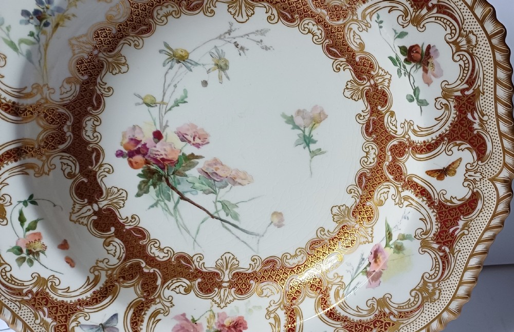 A circular late-Victorian Royal Worcester porcelain soup dish featuring hand-painted botanical floral and insect motifs enclosed within elaborate red and gold gilded rococo scroll borders. View IV