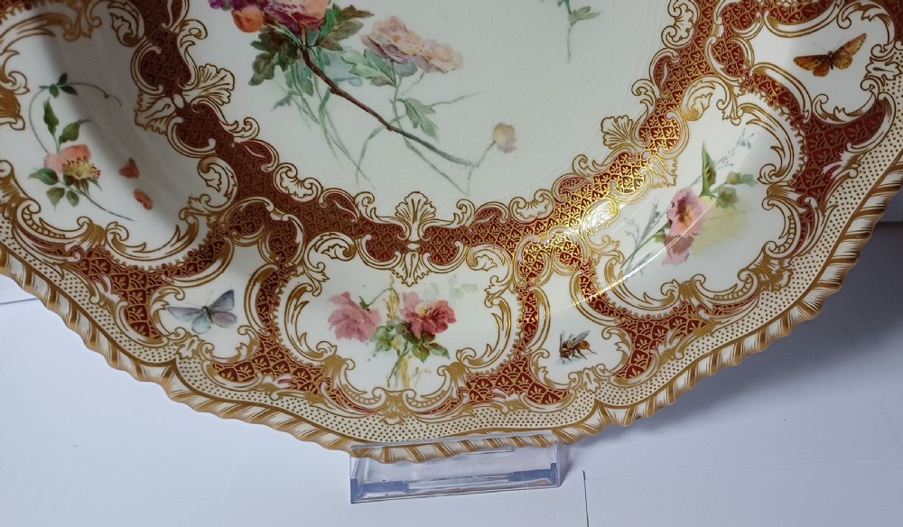 A circular late-Victorian Royal Worcester porcelain soup dish featuring hand-painted botanical floral and insect motifs enclosed within elaborate red and gold gilded rococo scroll borders. View XIII