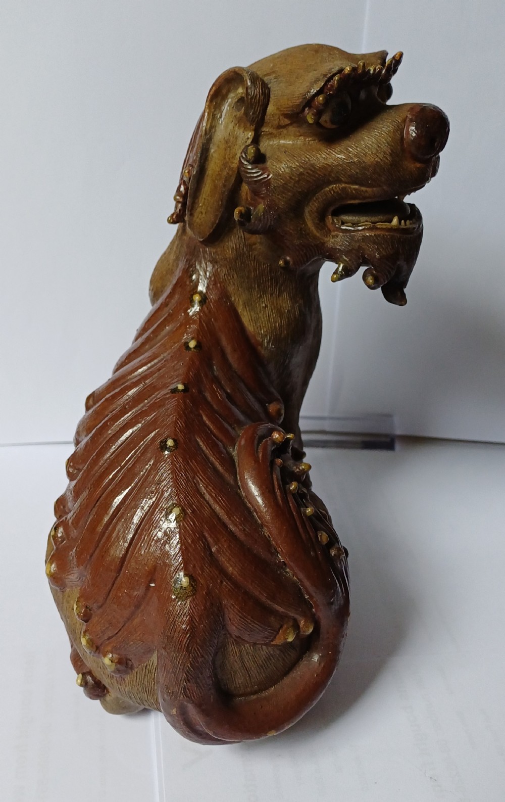 A pair of antique brown glazed ceramic Chinese Shiwan Buddhistic lion dogs depicted sitting upright with open mouths and detailed carved fur. View VII