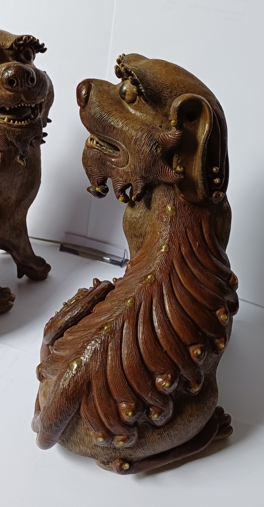 A pair of antique brown glazed ceramic Chinese Shiwan Buddhistic lion dogs depicted sitting upright with open mouths and detailed carved fur. View VIII