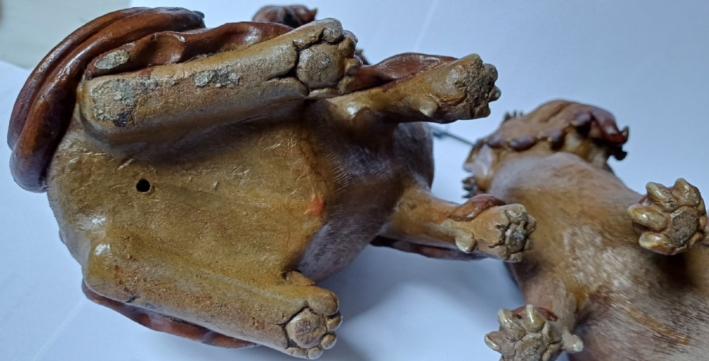 A pair of antique brown glazed ceramic Chinese Shiwan Buddhistic lion dogs depicted sitting upright with open mouths and detailed carved fur. View XVII