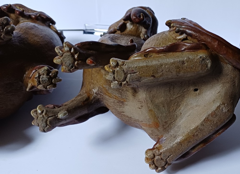 A pair of antique brown glazed ceramic Chinese Shiwan Buddhistic lion dogs depicted sitting upright with open mouths and detailed carved fur. View XVIII