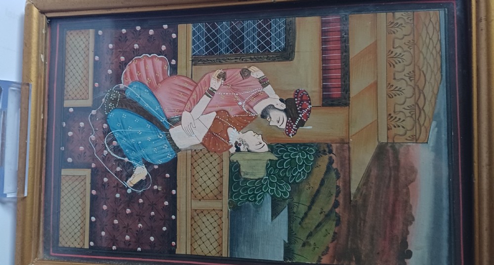 A late 19th-century framed Indian gouache miniature painting depicting a royal couple embracing on a terrace, set within a gilt wood frame. View II