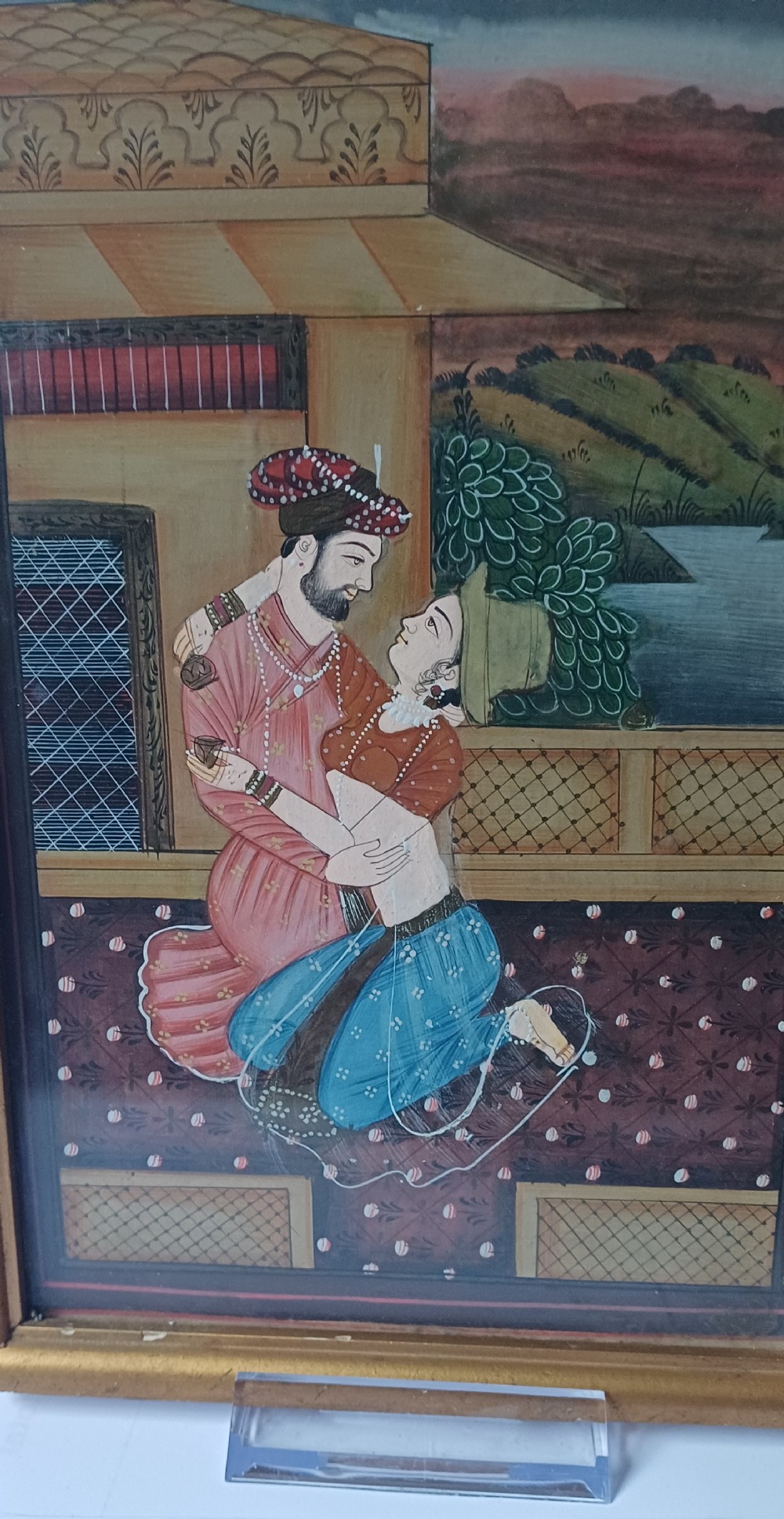 A late 19th-century framed Indian gouache miniature painting depicting a royal couple embracing on a terrace, set within a gilt wood frame. View III