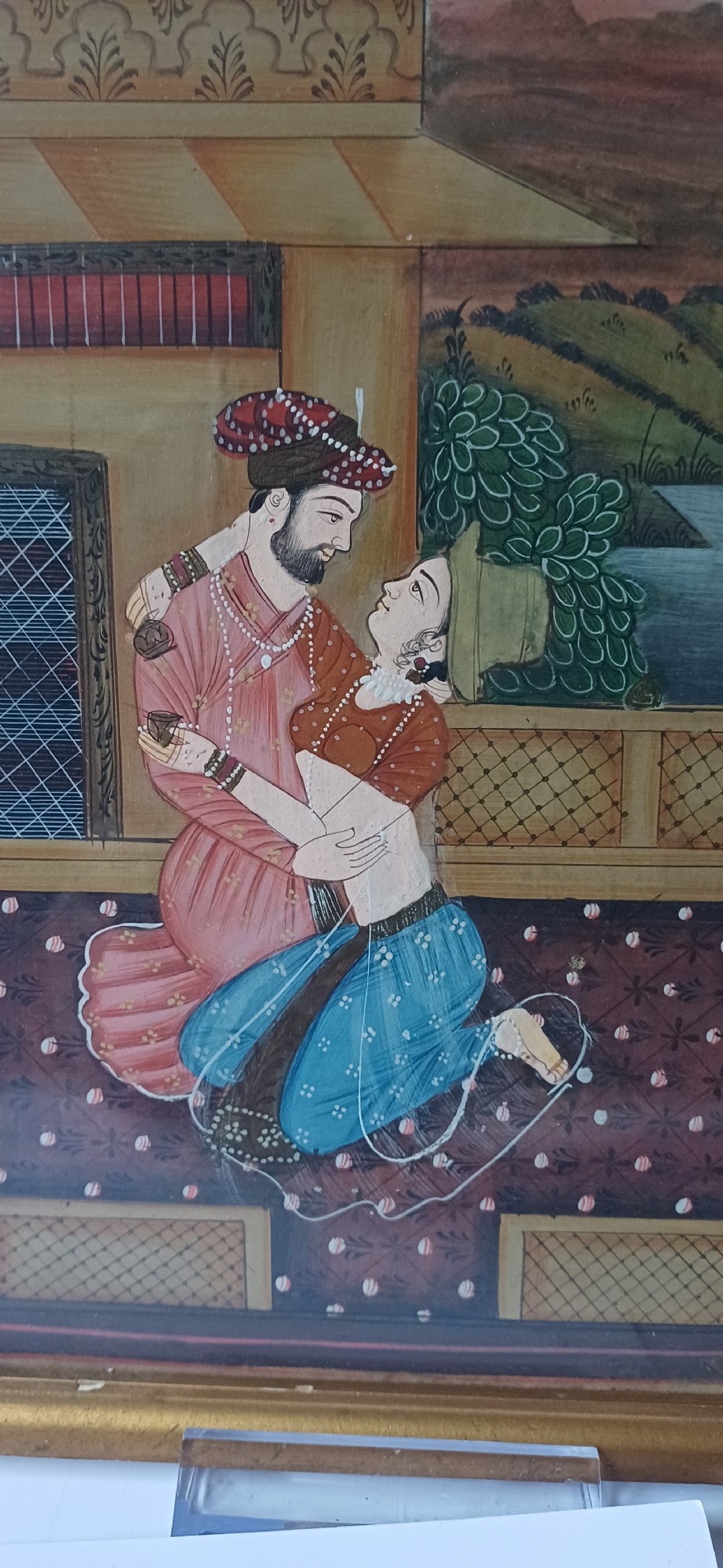 A late 19th-century framed Indian gouache miniature painting depicting a royal couple embracing on a terrace, set within a gilt wood frame. View IV