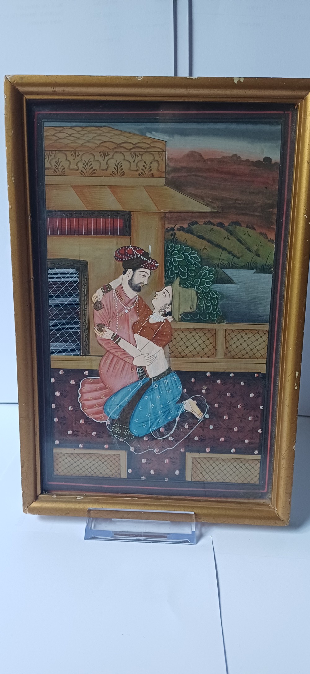 A late 19th-century framed Indian gouache miniature painting depicting a royal couple embracing on a terrace, set within a gilt wood frame. View VII