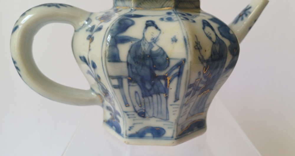 An octagonal Chinese porcelain teapot decorated with cobalt blue figures in landscapes and gold leaf highlights. View IX
