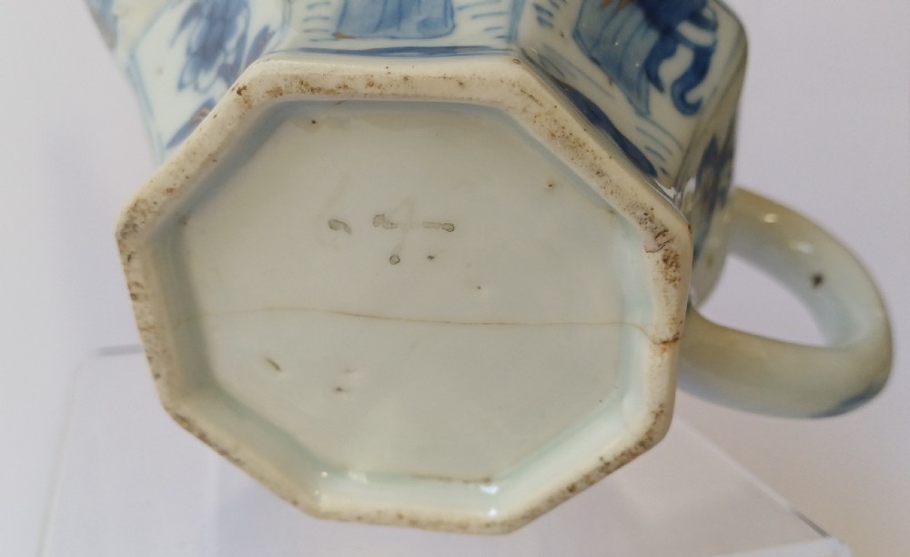 An octagonal Chinese porcelain teapot decorated with cobalt blue figures in landscapes and gold leaf highlights. View XIX