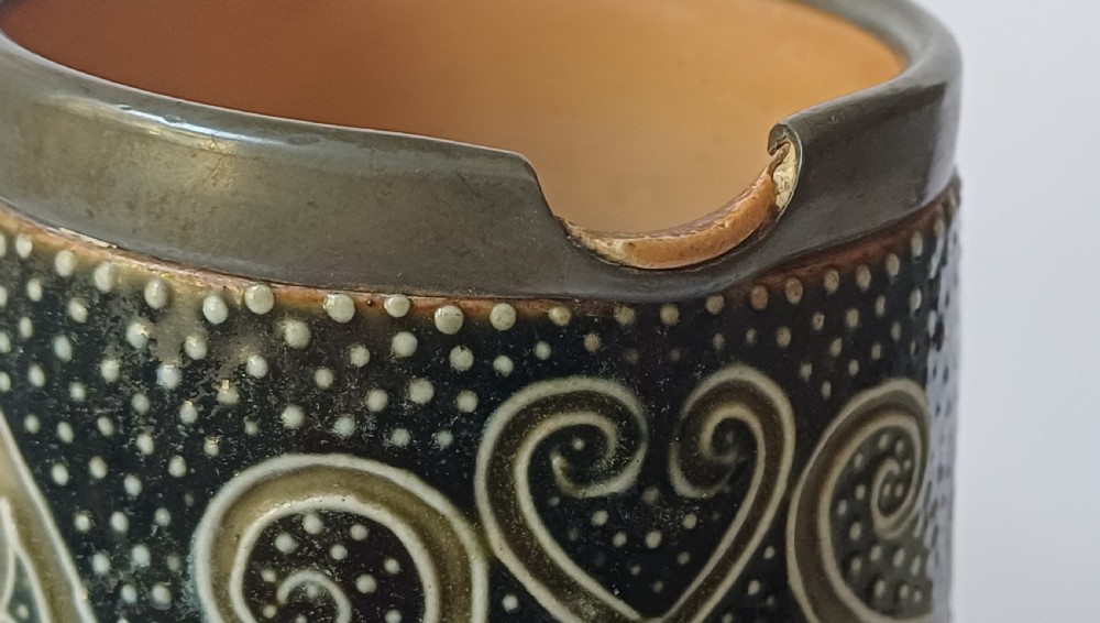 An Art Nouveau Doulton Lambeth glazed stoneware jug featuring relief figures of sports players alongside dark brown glazes and stylised swirl patterns. View XIII