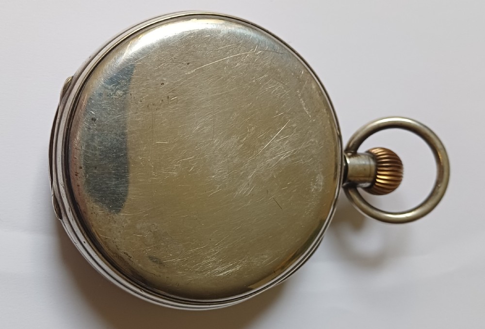 An oversized Edwardian silver-cased pocket watch featuring a black dial with white Roman numerals and a brass winding crown. View IV