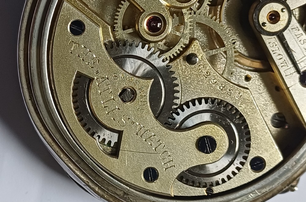 An oversized Edwardian silver-cased pocket watch featuring a black dial with white Roman numerals and a brass winding crown. View IX