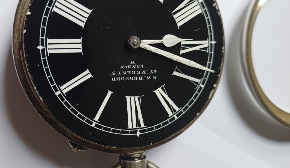 An oversized Edwardian silver-cased pocket watch featuring a black dial with white Roman numerals and a brass winding crown. View XIII