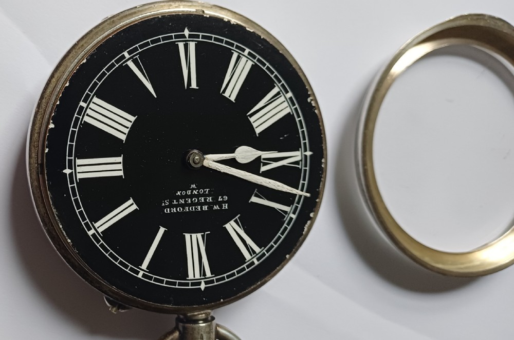 An oversized Edwardian silver-cased pocket watch featuring a black dial with white Roman numerals and a brass winding crown. View XIV