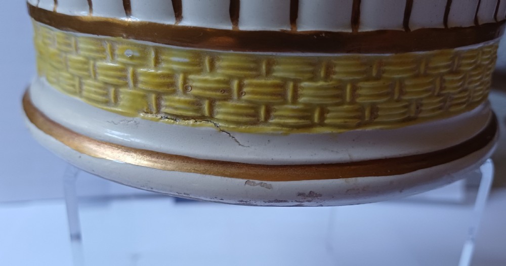 A Georgian pearlware ceramic mug featuring polychrome relief-moulded floral garlands, basketweave bands, gilt accents, and the word WARRANTED. View V