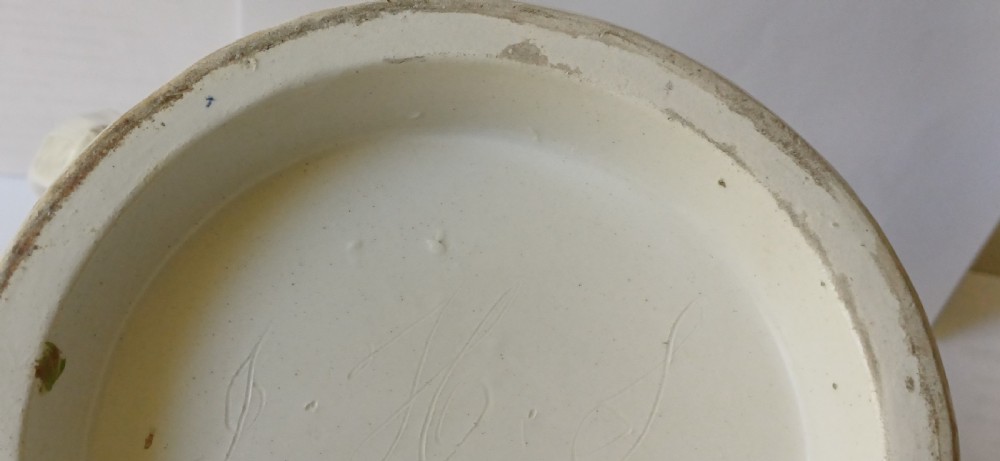 A Georgian pearlware ceramic mug featuring polychrome relief-moulded floral garlands, basketweave bands, gilt accents, and the word WARRANTED. View XV