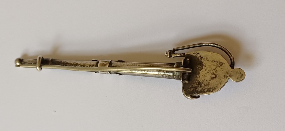 An antique silver kilt pin crafted in the shape of a Scottish basket-hilted broadsword inlaid with green and brown polished agate stones. View VII