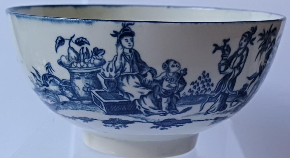 An eighteenth-century circular soft-paste porcelain bowl decorated with a hand-painted chinoiserie scene in underglaze blue on a cream background. View VI