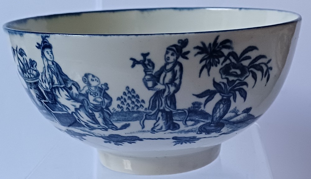 An eighteenth-century circular soft-paste porcelain bowl decorated with a hand-painted chinoiserie scene in underglaze blue on a cream background. View VII