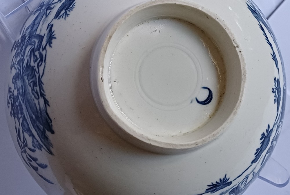 An eighteenth-century circular soft-paste porcelain bowl decorated with a hand-painted chinoiserie scene in underglaze blue on a cream background. View X