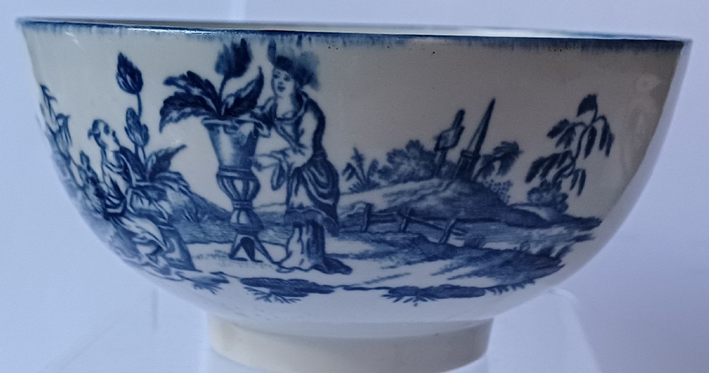 An eighteenth-century circular soft-paste porcelain bowl decorated with a hand-painted chinoiserie scene in underglaze blue on a cream background. View XIV